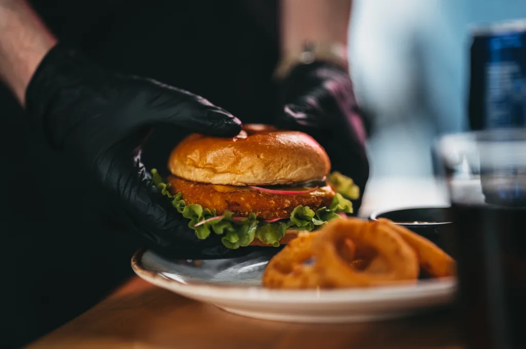 close up photo a a man holding streetfood burger